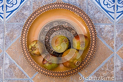 Pomegranates on pattered wooden plate. Tiles Stock Photo