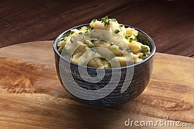 Pomme puree, a photo of a bowl of mashed potatoes with herbs on a rustic background Stock Photo