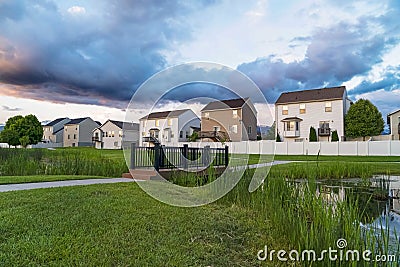 Pond with bridge at a park in front of homes with balconies and bay windows Stock Photo