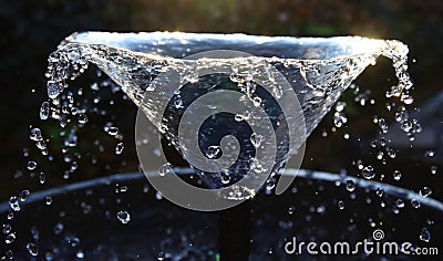 Sunlit pond fountain with water droplets Stock Photo