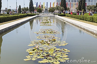 Pond with water lilies in Lisbon, colorful flags in the background. Portugal Editorial Stock Photo