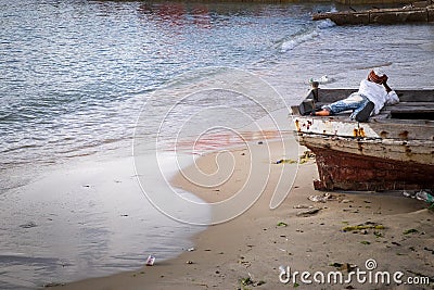 A young boy laying in a boat appearing to be in deep thought Stock Photo