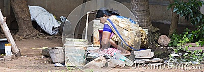 Indian poor woman wash clothes in street rural village Editorial Stock Photo