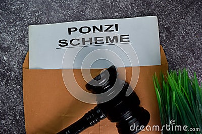 Ponzi Scheme text with document brown envelope and gavel isolated on office desk Stock Photo