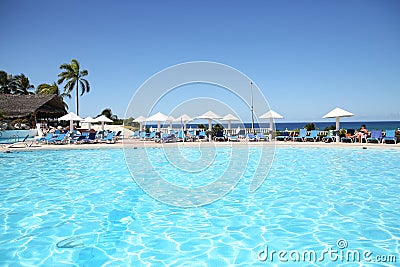 Pool with blue water and white umbrellas in a tropical resort. Editorial Stock Photo