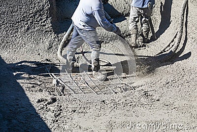 Pool Construction Worker Shooting Concrete, Shotcrete or Gunite Through Hose Stock Photo