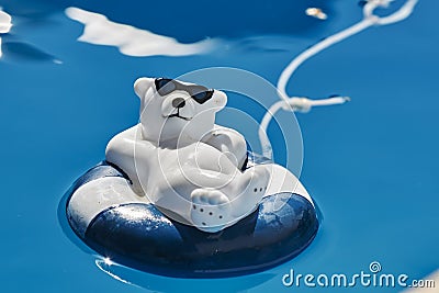 Pool decoration in the form of a relaxed bathing polar bear with sunglasses and a swim ring Stock Photo