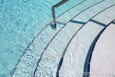 Pool Steps and Guide Rail Leading to Water Stock Photo