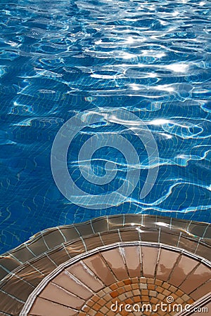 Poolside with steps and clean blue water Stock Photo