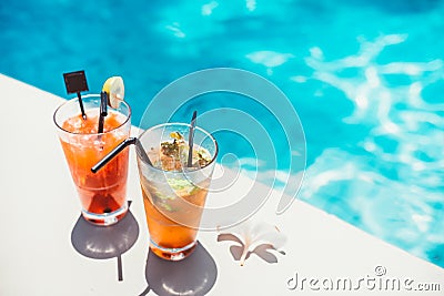 Poolside symmetric cocktails served cold at pool bar with mojito and gin and tonic lemonade Stock Photo