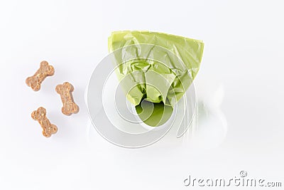 Poop bags with dog treats on white background Stock Photo