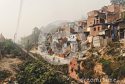 Poor area of Haridwar, India. House poor people on the hillside in front of a dirty river. Editorial Stock Photo