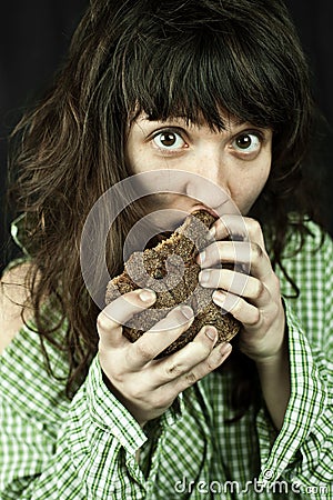 Poor beggar woman eating bread Stock Photo