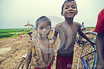 Poor cambodian kids playing with bicycle Editorial Stock Photo