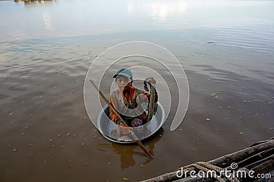 The poor child floats in a basin of dirty Tonle SAP lake Editorial Stock Photo