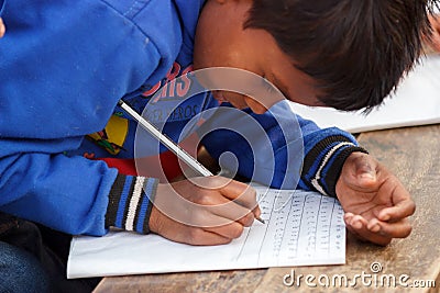 Poor child learning, writing Editorial Stock Photo