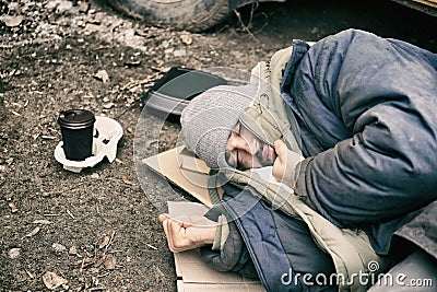 Poor homeless man lying on ground Stock Photo