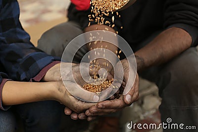 Poor homeless people taking wheat from donator outdoors Stock Photo