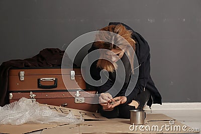 Poor homeless woman with suitcase counting coins Stock Photo