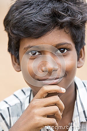 Poor indian boy with a sad and serious eyes looks at the camera Editorial Stock Photo