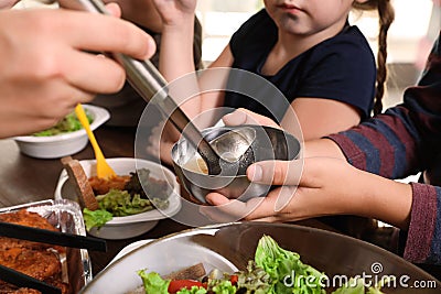 Poor little children receiving food from volunteer in charity centre Stock Photo