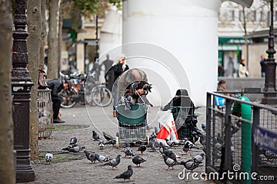 poor man feeding pigeons in the street Editorial Stock Photo