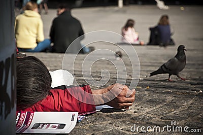 Poor man lying down in Paris Editorial Stock Photo