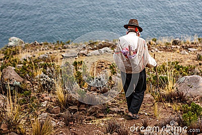 Poor man walking down a cliff, Taquile Island, Titicaca lake, Peru Editorial Stock Photo