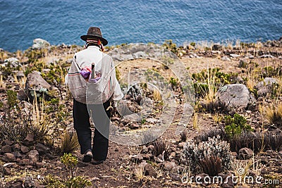 Poor man walking down a cliff, Taquile Island, Titicaca lake, Peru Editorial Stock Photo