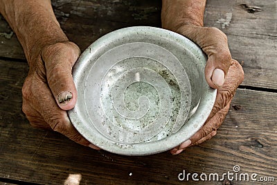 The poor old man& x27;s hands hold an empty bowl of beg you for help. Stock Photo