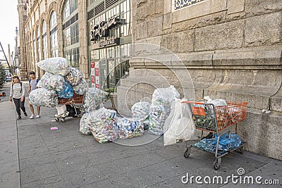 Poor people collect cans and plastic bottles and sell them back to shops. They earn money by getting a small deposit on the cans Editorial Stock Photo