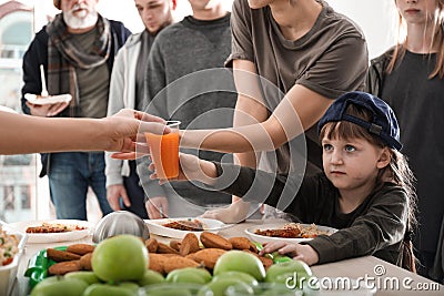 Poor people receiving food from volunteers Stock Photo