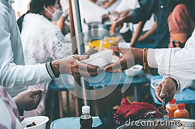 Poor people's hands share free food from volunteers who donate food : concept of feeding, sharing food Stock Photo