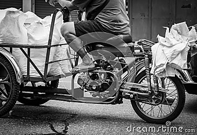 Poor senior man driving a motorbike, sending ice bag to a restaurant. Elderly people work after retirement. Retirement money Stock Photo