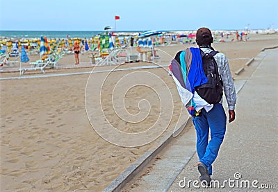 poor walking salesman along the beach Editorial Stock Photo