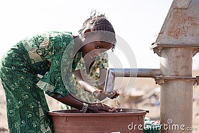 Poor West Africa Youngster with pure Water in a rural village Stock Photo