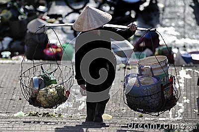 A poor woman in busy market in Vietnam Editorial Stock Photo