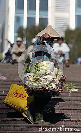 A poor woman in busy market in Vietnam Editorial Stock Photo