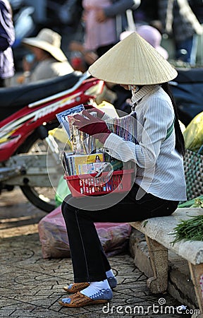 A poor woman in busy market in Vietnam Editorial Stock Photo