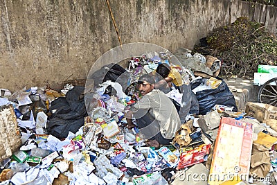 Poor worker checking garbage for Editorial Stock Photo