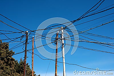 Poorly laid electrical wires on crooked rusty pillars Stock Photo