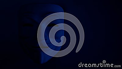 Poorly visible mask on a dark background in blue. An anonymous hacker or halloween party symbol. Copy space. Shooting a subject in Editorial Stock Photo