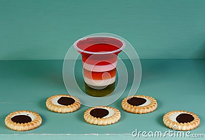 Pop art still life. Plastic glass striped jelly and biscuits Stock Photo