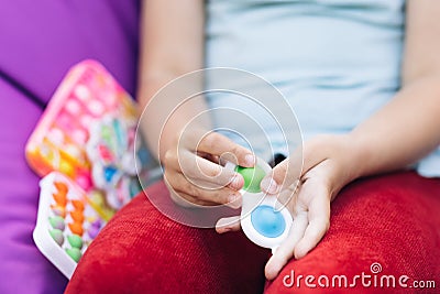 Pop it simple dimple popit anti-stress sensory toy for children. Girl hands playing with toy. Topview of playing a Stock Photo