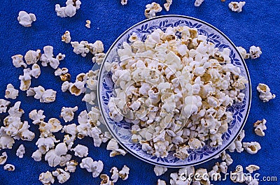 Popcorn in dish and on blue clothes floor Stock Photo