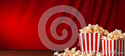 Popcorn filled striped box on textured red gradient background with ample empty space Stock Photo