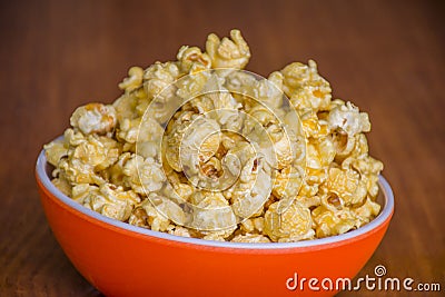 Popcorn in orange bowl Brown background Stock Photo