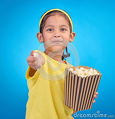 Popcorn, offer and smile with portrait of girl and giving snack to you for food, cinema and relax. Friendly, movie and Stock Photo