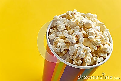 Popcorn in papercup against yellow background Stock Photo