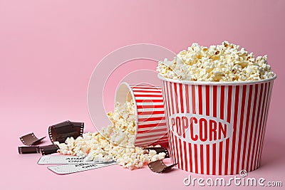 Popcorn, tickets and film footage on pink. Cinema snack Stock Photo